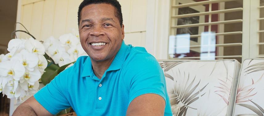 A middle-aged man wearing a blue polo shirt and smiling after receiving same-day crowns in Tappan