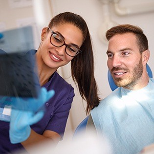 Dentist and dental paitent looking at x-rays