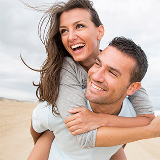 Young couple smiling while on the beach 