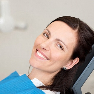 A young female smiles while seated in the dentist’s chair in Tappan