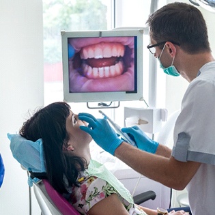 A dentist reviews a patients smile using advanced technology during a dental checkup in Tappan