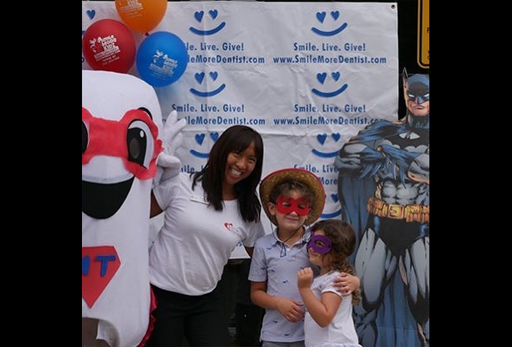 Dr. LaCap smiling with two kids at community event