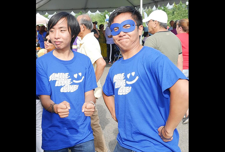 Dr. Tong and child smiling during community event