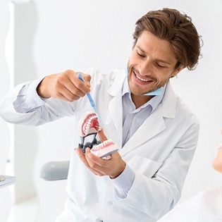 A dentist explains to a female patient how a dental bridge will make a difference in her smile