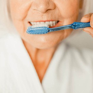 closeup of woman brushing teeth 