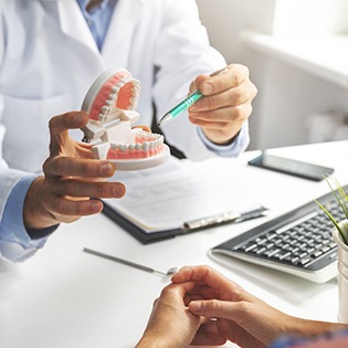 a dentist explaining the cost of dentures to a patient