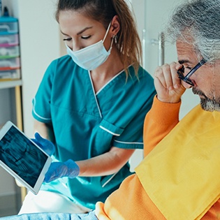 a dentist showing a patient X-rays of their teeth