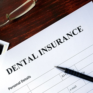 a dental insurance form on a table next to glasses
