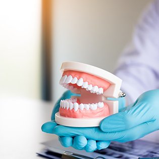 dentist holding dentures in hand 