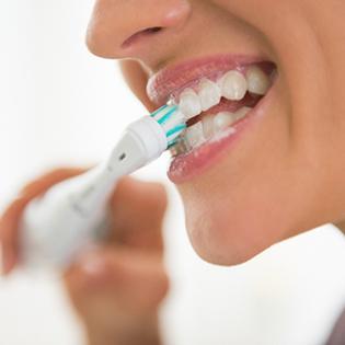 Closeup of smiling woman brushing her teeth