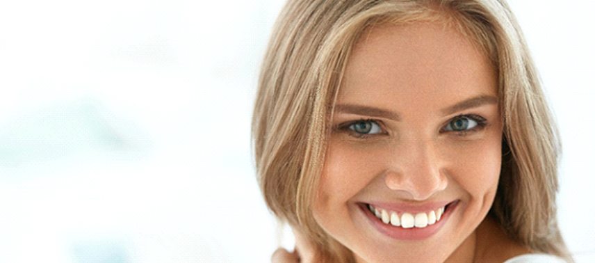 A young female shows off her newer, brighter smile thanks to teeth whitening in Tappan