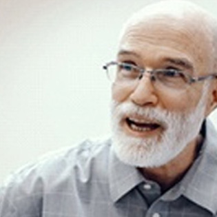 Smiling older man talking to his Tappan implant dentist 