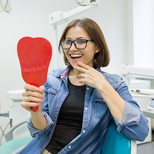 Woman looking at her smile in the mirror