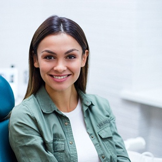 A woman sitting in the dentist chair smiling