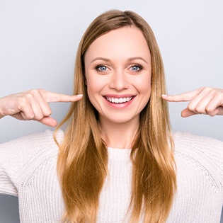 Woman pointing to her smile