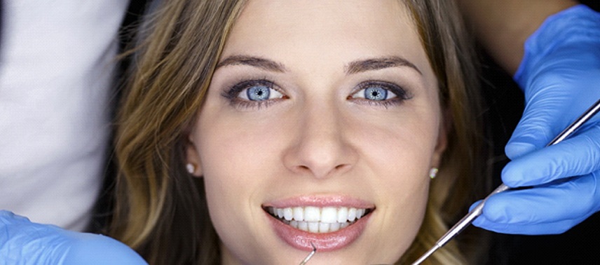 A woman with a straight, beautiful smile at the dentist’s office