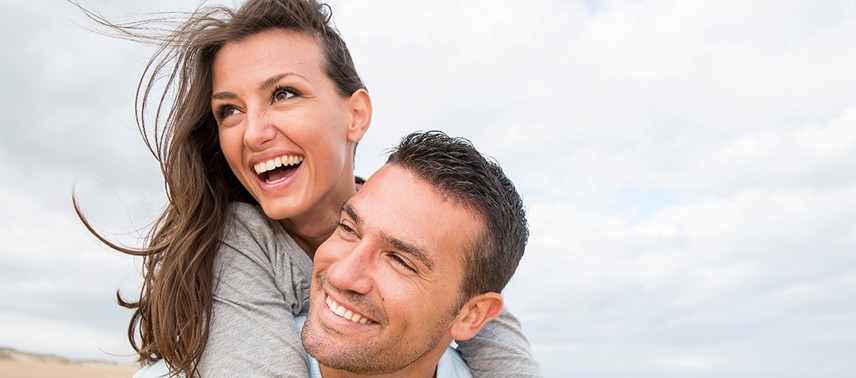 Young couple smiling while on the beach 