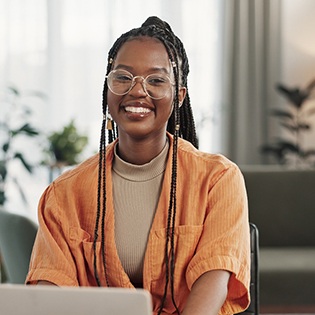 Smiling female reading information on her laptop