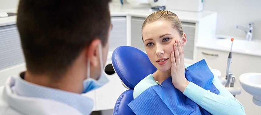 Woman in pain holding jaw