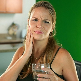 Woman holding cheek in pain