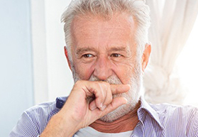 Older man covering his mouth