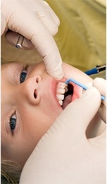 A young patient undergoes fluoride treatment during a regular checkup and cleaning appointment in Tappan