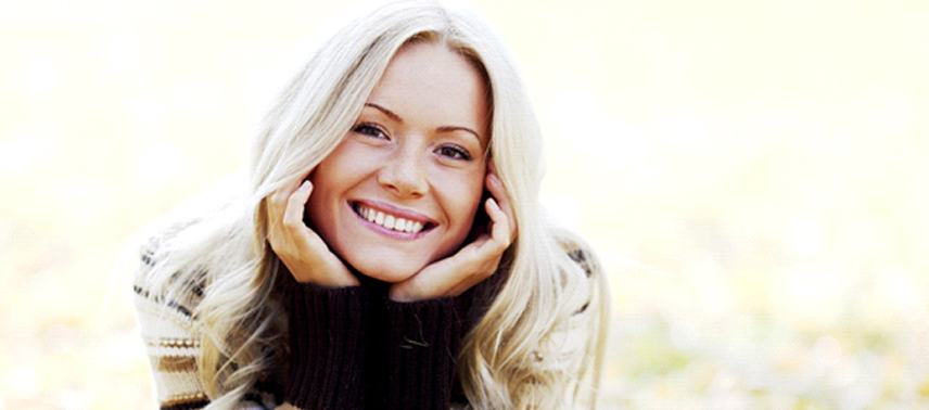 A young woman lying in the leaves and smiling