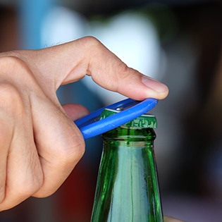 Closeup of patient using blue bottlecap opener