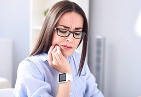 Woman in pain holding jaw