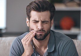 Man in pain holding jaw