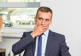 Man in business suit covering his mouth