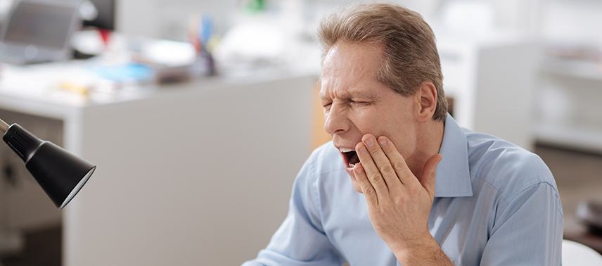Man in pain holding jaw