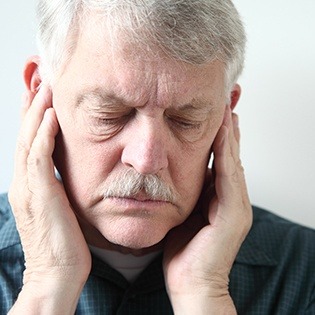 Man holding both sides of jaw