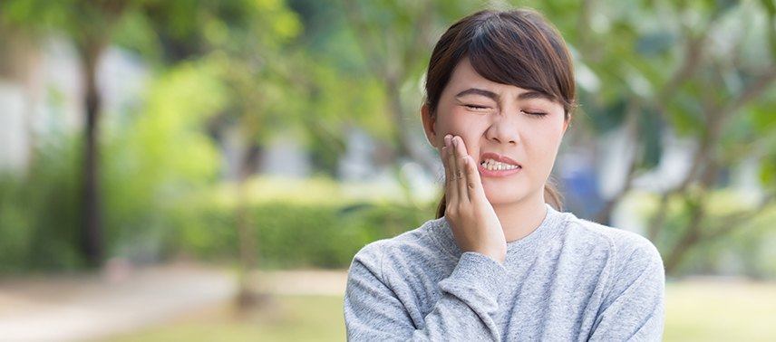 Woman holding jaw in pain