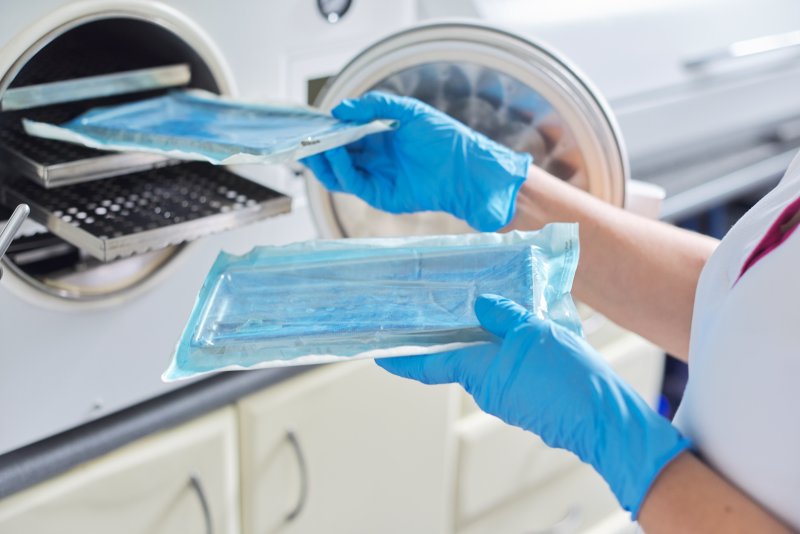 a dental assistant cleaning instruments used in a dentist’s office