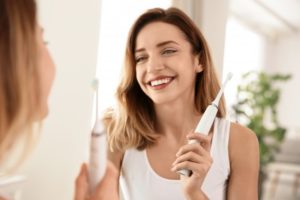 Woman practicing oral hygiene to protect tooth enamel