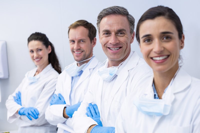 a team of dentists and specialists smiling in preparation for treating dental patients