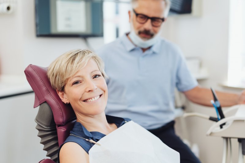 a woman smiling while visiting her dentist for a regular dental checkup in Northvale