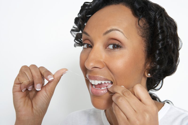 a woman flossing her teeth